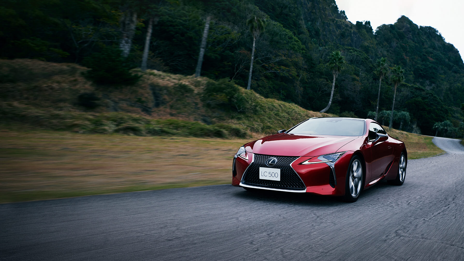 Red Lexus LC 500 being driven on the road.