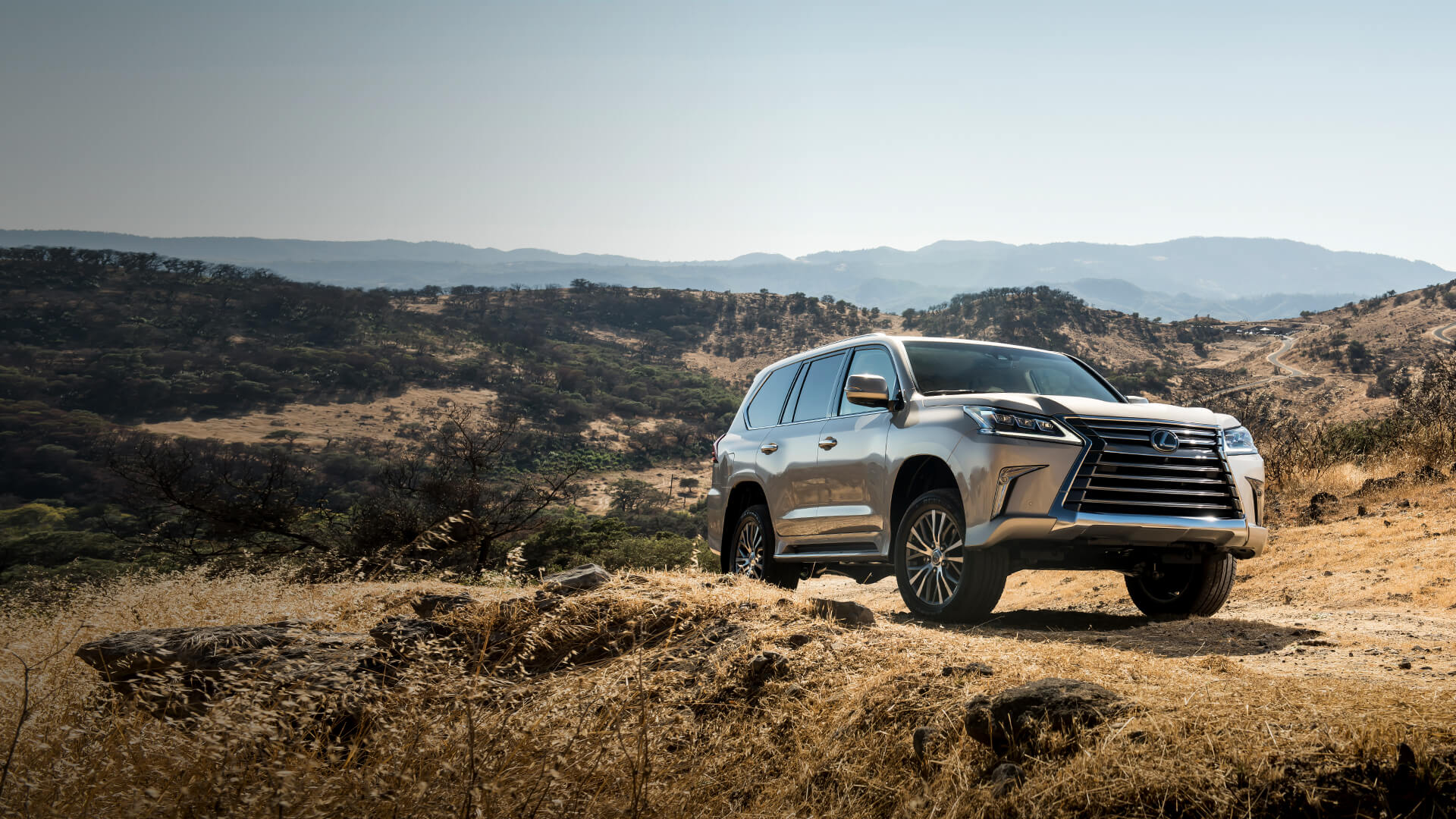 Silver Lexus LX being driven on mountainous terrain.